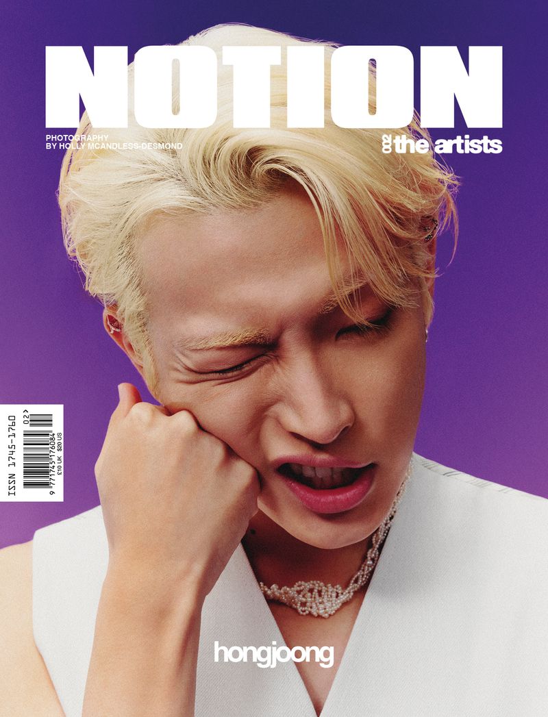 Magazine cover featuring a close-up portrait of an Asian male model with blonde hair against a solid purple background, expressive pose.