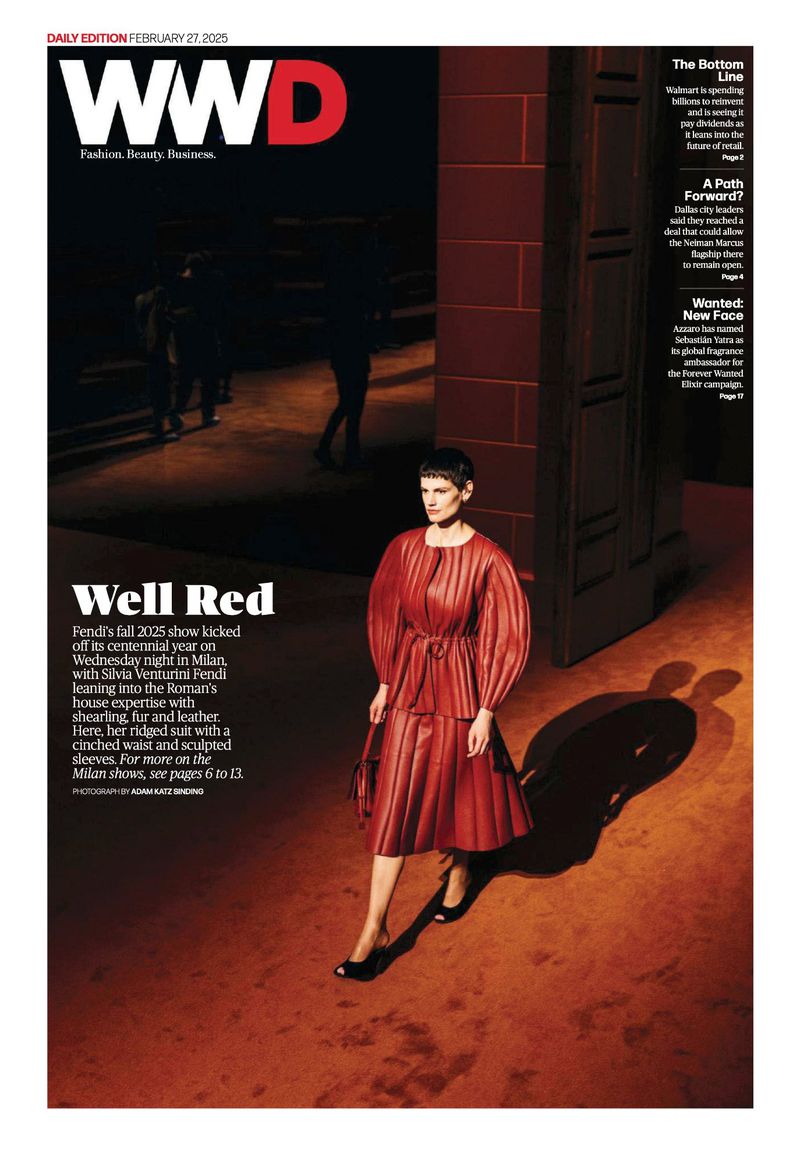 WWD cover featuring a model in a red dress, standing on a red floor, with a blurred figure in the background and brand logo.