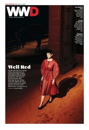 Model Saskia de Brauw walking in a pleated red leather dress on a lit runway for the WWD magazine cover.