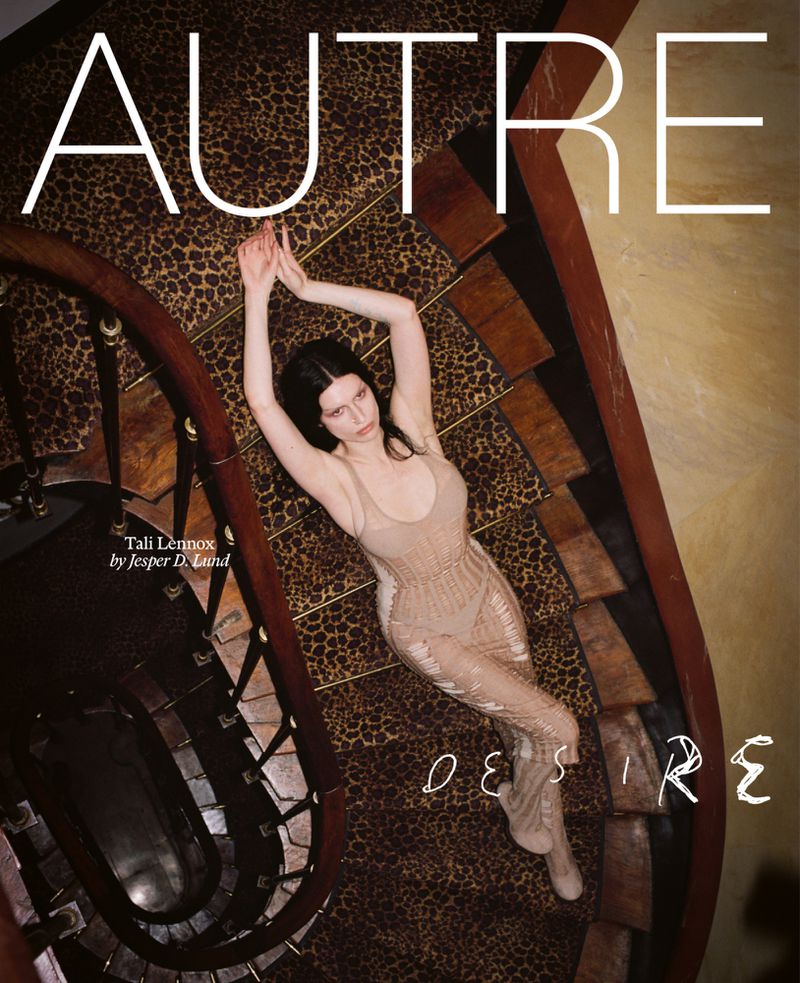 Fashion magazine cover featuring a young woman in a beaded body suit lying on a leopard print spiral staircase with title text.