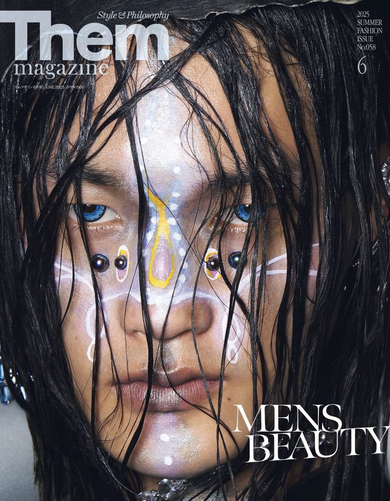 Magazine cover featuring a close-up portrait of a person with wet dark hair, blue eyes, facial piercings, and face paint in a beauty context.