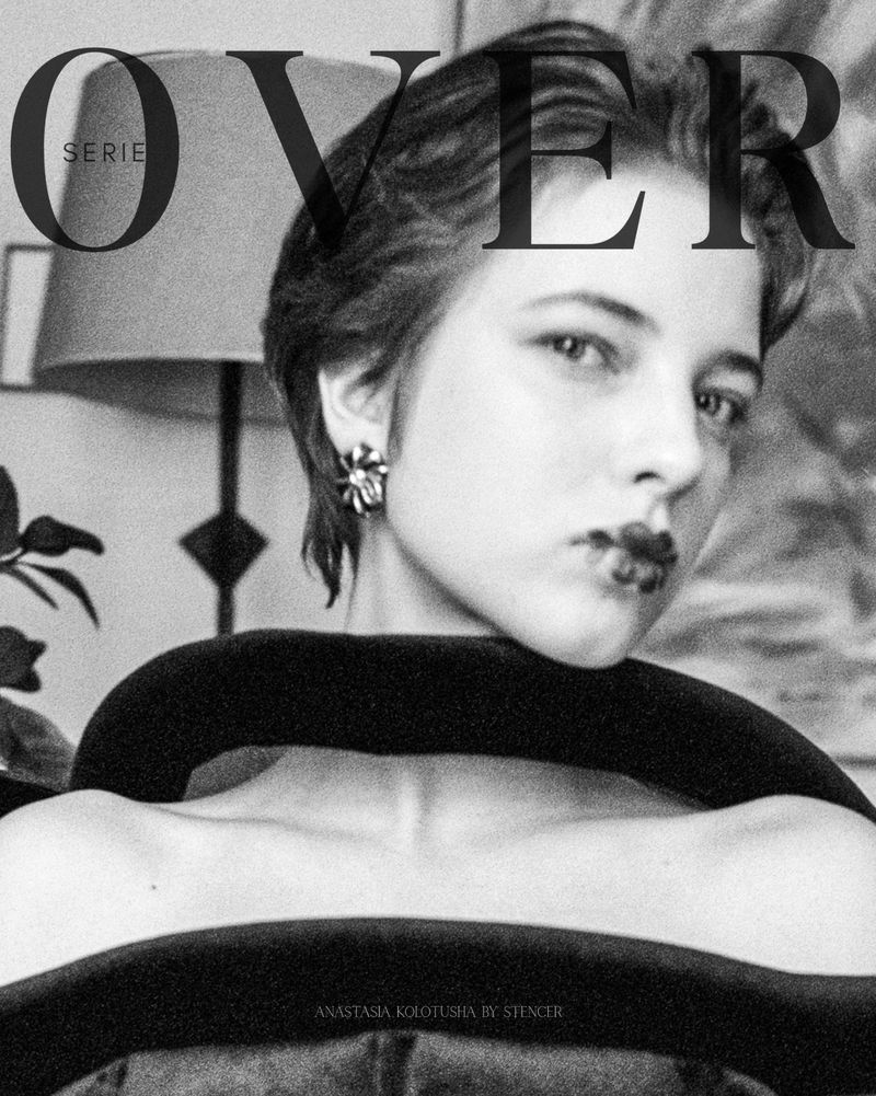 Black and white portrait of a woman with short hair, floral earring, and sculptural collar under the typography OVER SERIE.
