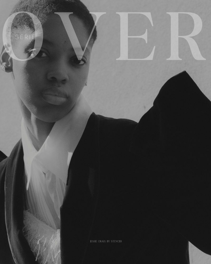 Black and white fashion portrait of a Black woman wearing a white collared shirt and black jacket, overlaid with magazine typography.