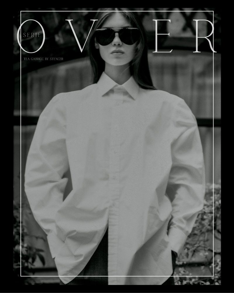 Model in dark sunglasses wearing a white oversized shirt against an outdoor backdrop for OVER series by Stencer Saintelange