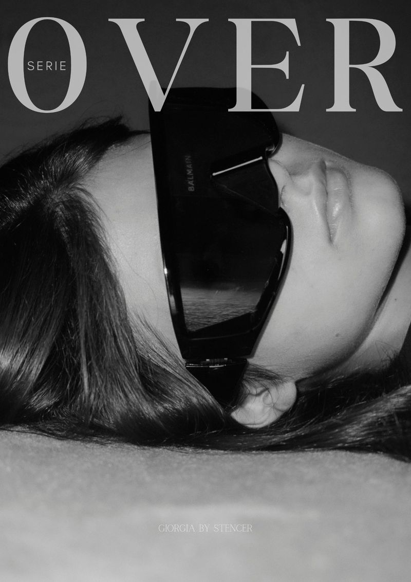 Black and white portrait of a woman wearing large sunglasses, promoting a fashion magazine with the text 'OVER' visible.