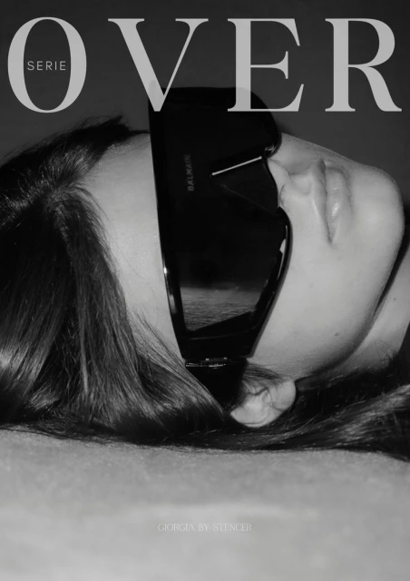 Black and white portrait of a woman wearing large sunglasses, promoting a fashion magazine with the text 'OVER' visible.