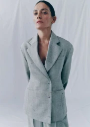 Model Laura Ponte wearing a grey textured blazer against a white seamless background for Zara