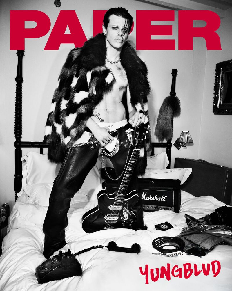 Magazine cover featuring a shirtless male model in a fur coat and leather pants, holding a guitar, with 'PAPER' and 'YUNGBLUD' text.