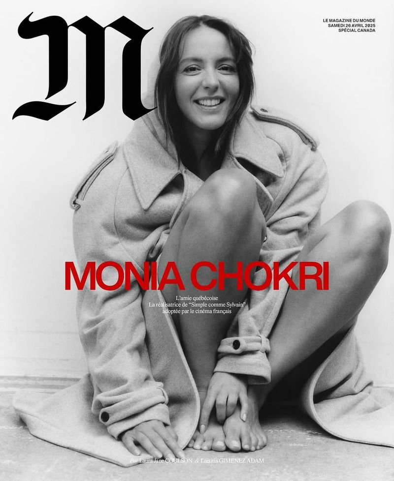 Magazine cover featuring model Monia Chokri, squatting indoors, wearing a beige overcoat and smiling against a white backdrop.