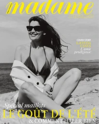 Model Laetitia Casta wearing sunglasses and a bikini on a sandy beach for a Madame Figaro cover photographed by Charlotte Navio