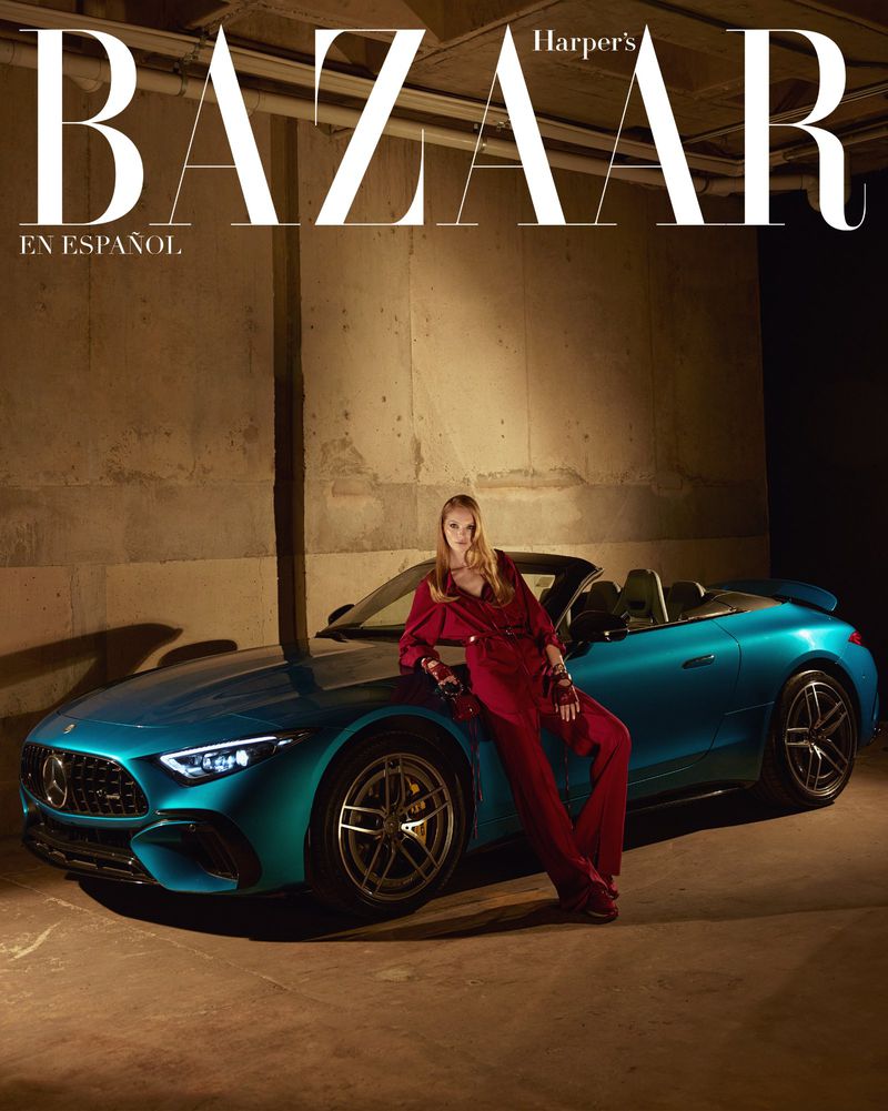 Magazine cover featuring a woman in a red suit leaning on a turquoise Mercedes-Benz car against a concrete wall backdrop with 'BAZAAR' text.