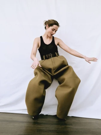 Ana de Armas wearing a black tank top and voluminous olive trousers against a white backdrop for WWD.
