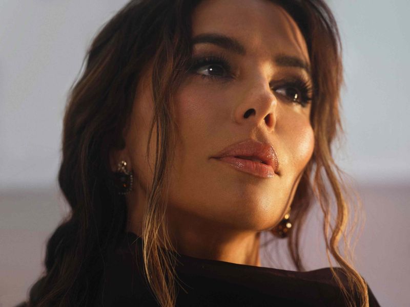 Close-up portrait of Eva Longoria with dark hair and warm lighting for Byrdie Summer Issue 2025
