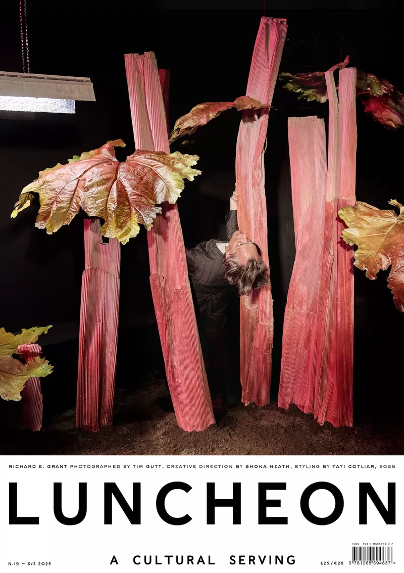Luncheon magazine cover featuring a person amongst tall rhubarb stalks and leaves, in a dark studio setting with light fixtures.