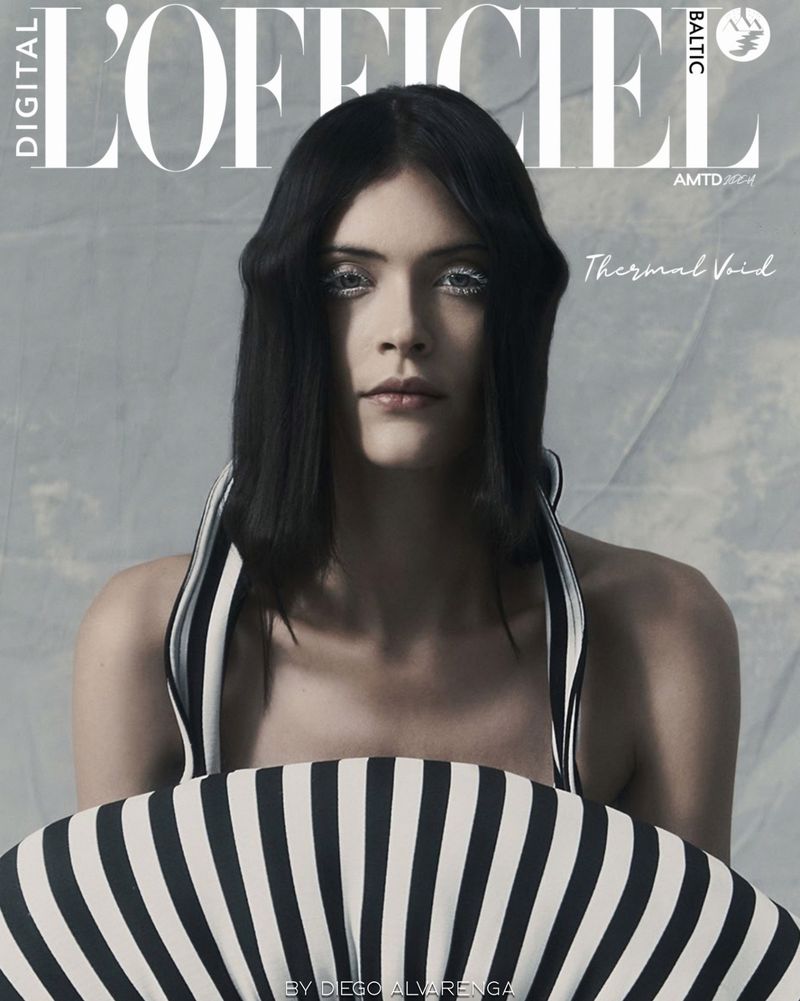 L'Officiel Baltic cover featuring a young woman with black hair and shimmering eye makeup holding a black and white fan.