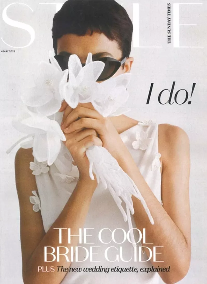Magazine cover featuring a bride with sunglasses and a flower bouquet covering her face, showcasing modern bridal fashion.