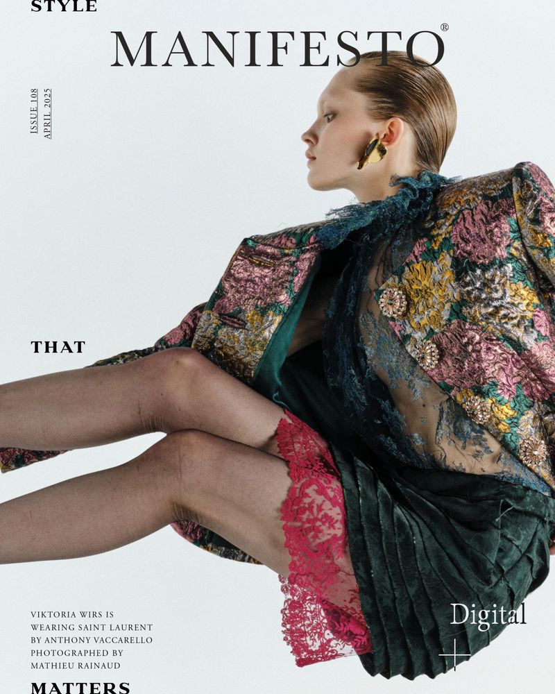 Magazine cover featuring a fair-skinned woman in high fashion attire, including a floral brocade jacket, lace top, and green pleated skirt.