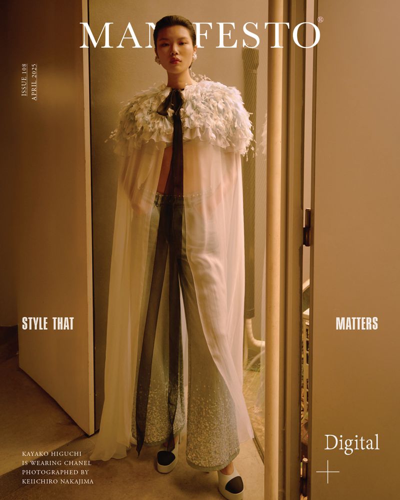 Magazine cover featuring Asian woman in cape, wide-leg pants, posing indoors; dramatic fashion editorial, soft lighting, and neutral color palette.