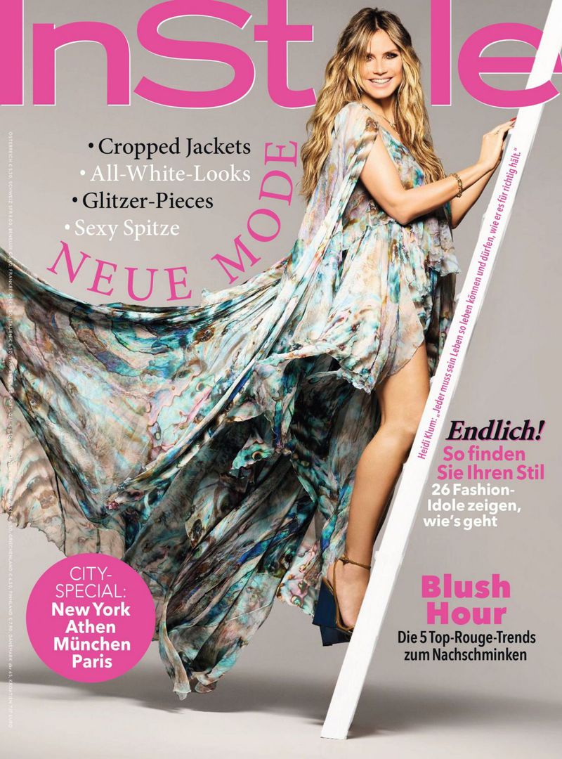 Heidi Klum graces an InStyle magazine cover, captured in a medium shot wearing a flowing floral dress, complemented by long, blonde hair.