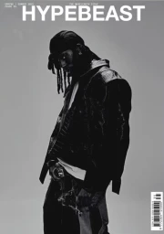 Portrait of Playboi Carti wearing a dark jacket and bandana against a solid grey background for Hypebeast cover