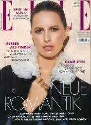 Model Karolina Kurkova wearing a black coat with a white feather ruff on the cover of Elle Germany April 2025.