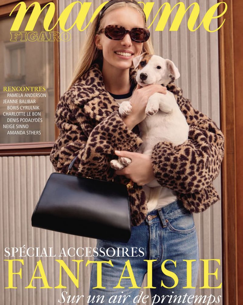 Magazine cover featuring a smiling woman in a leopard-print coat holding a Jack Russell Terrier puppy, accessorized with sunglasses and a purse.