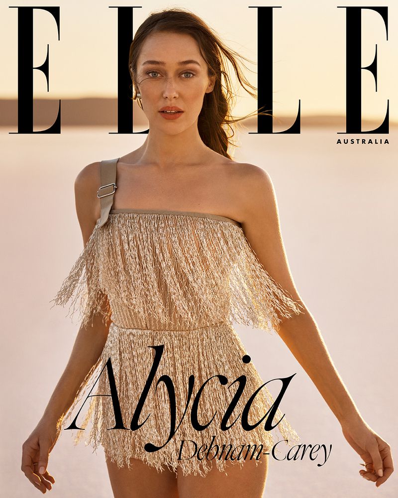 Elle Australia cover featuring Alycia Debnam-Carey in a gold fringed dress against a soft, warm-toned outdoor backdrop at sunset.