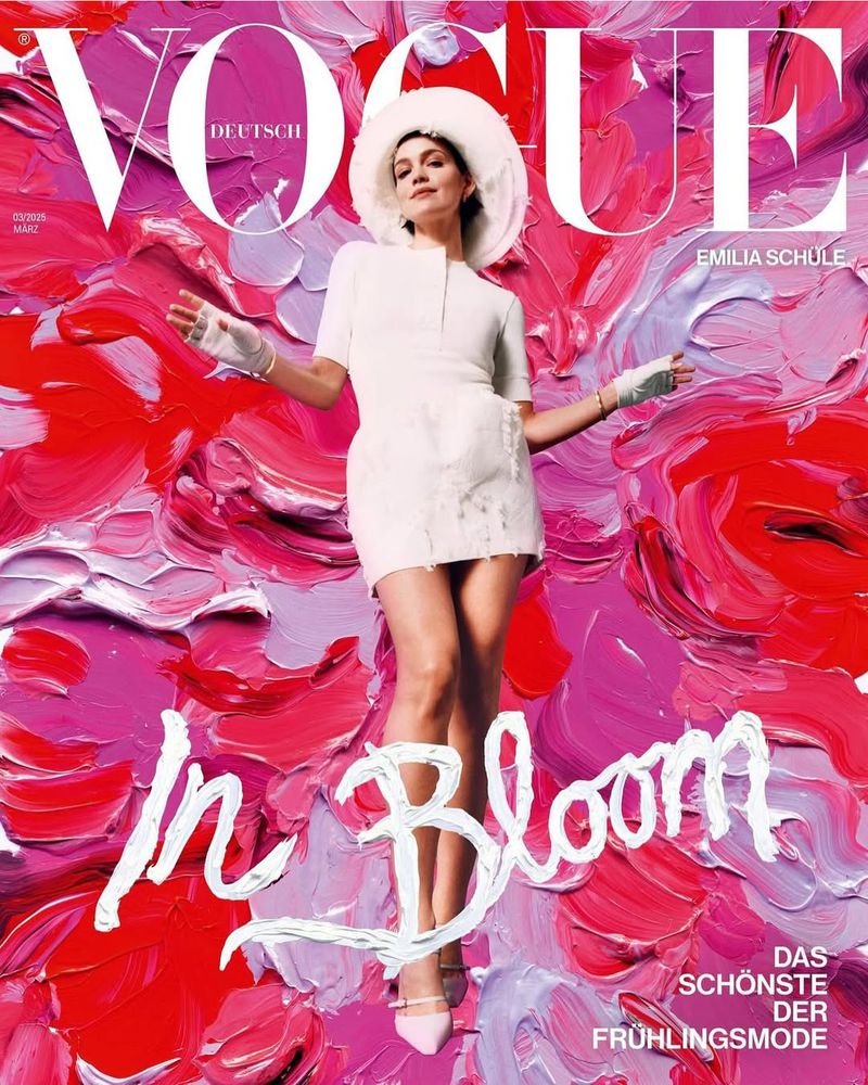 Vogue Deutsch magazine cover featuring Emilia Schule in a white mini dress, hat, and gloves against a vibrant painted background.