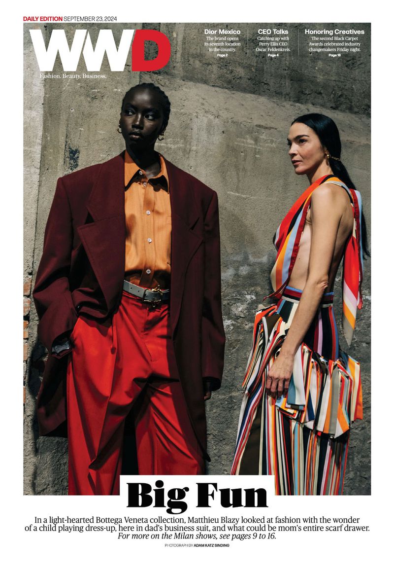 Two fashion models pose in an editorial shot for WWD magazine, wearing colorful Bottega Veneta outfits with a textured wall backdrop.