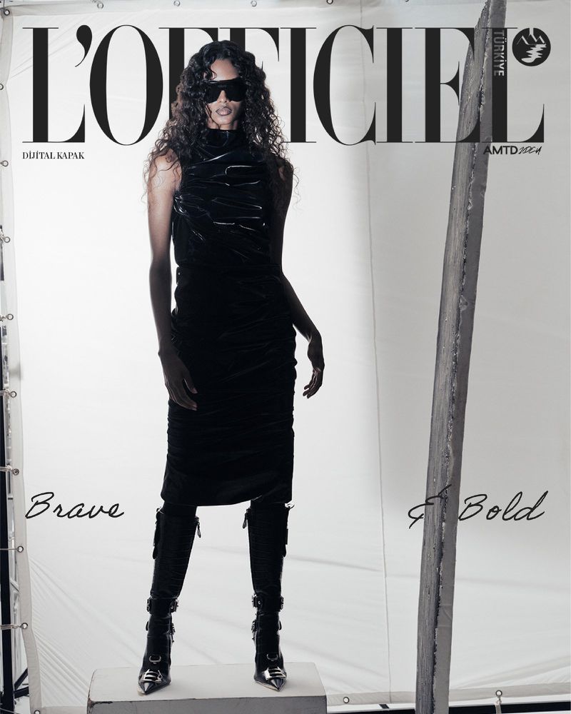 A woman wearing a black dress and boots standing in front of a white seamless background with L'Officiel Turkey cover text.