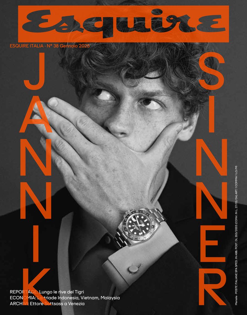 Esquire Italia magazine cover featuring a young man with curly hair covering his mouth, wearing a suit and a wristwatch.
