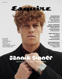 Jannik Sinner in a black blazer and wristwatch adjusting his collar for the Esquire UK Winter 2024 cover.