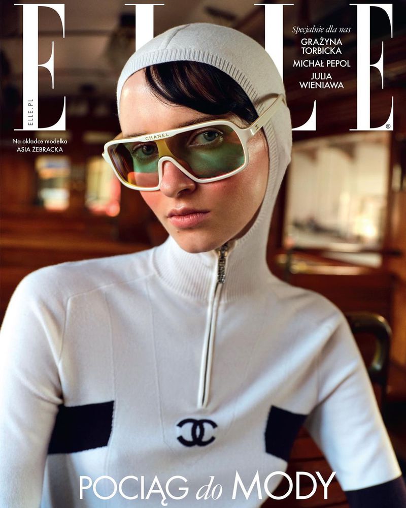 Elle magazine cover featuring model Asia Zebracka wearing a white head covering, white and black top, and large white-framed sunglasses.
