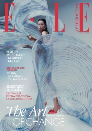 Magazine cover featuring a woman wrapped in flowing translucent blue fabric wearing red heels against a white backdrop.