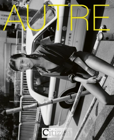 Black and white fashion editorial shot of a young Asian woman lying on a pedestrian barrier in front of a taxi, fashion and style.