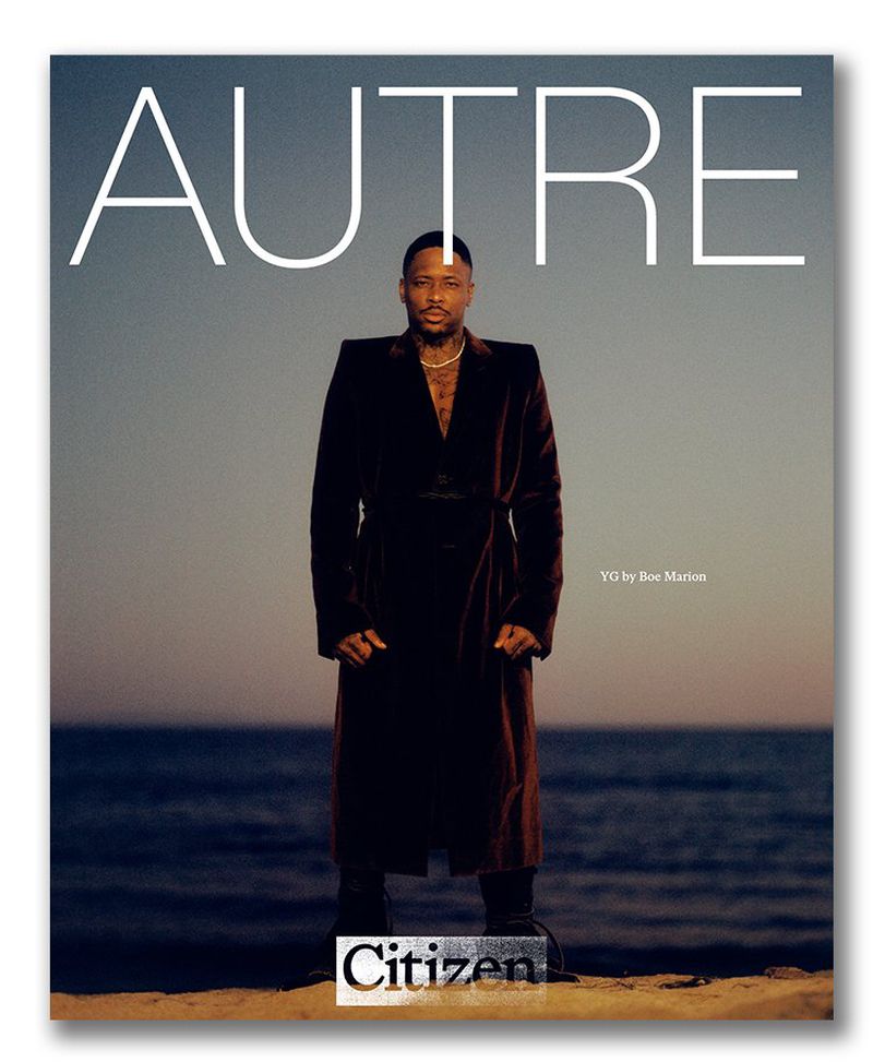 Magazine cover featuring a male model in a long coat posing on a beach at dusk, with the magazine title 'AUTRE' in large white letters.