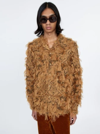 Model wearing dark sunglasses and a brown textured fringed shirt against a seamless white background.