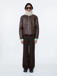 Model wearing dark sunglasses, brown jacket, and fur collar against a solid white background for Sefr Fall/Winter 2024 Rhythm Lookbook
