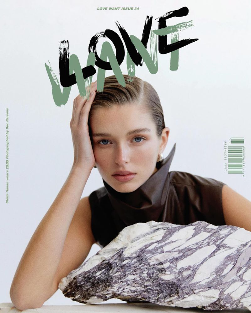 Magazine cover featuring a model with slicked-back hair, posing with her hand near her head, alongside a marble stone.
