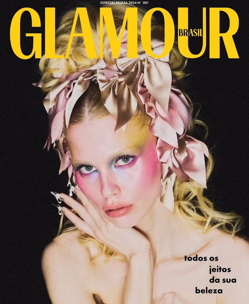 Glamour Brasil magazine cover featuring a woman with elaborate makeup, ribbons, and coiffed hair against a dark backdrop.