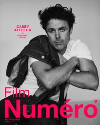 Black and white portrait of actor Casey Affleck in a white t-shirt and dark denim jacket for Numéro Netherlands cover.