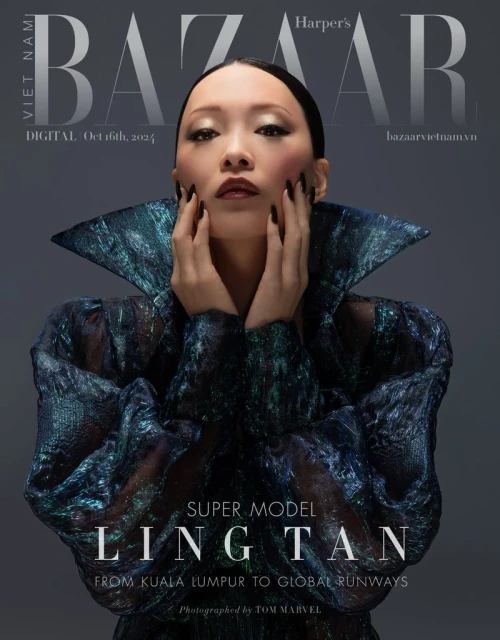 Fashion magazine cover featuring an Asian woman with hands framing her face, wearing a reflective textured dress with a wide collar.