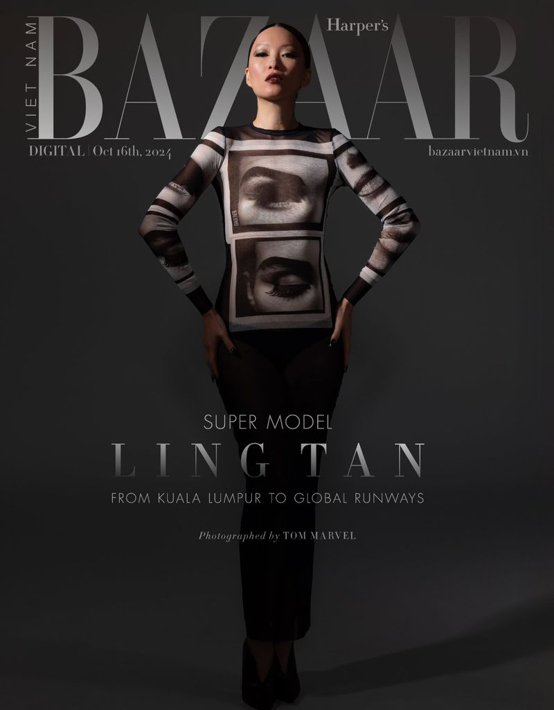Fashion editorial shot of an Asian female model wearing a black and white patterned top, posing in front of a gray studio backdrop.