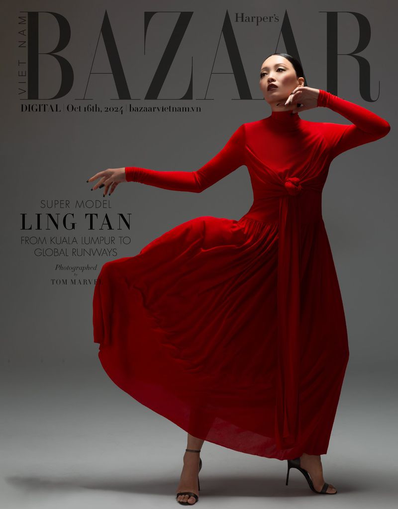 Fashion editorial photo of Ling Tan in flowing red gown for Harper's Bazaar, posing elegantly in a studio with soft, diffused lighting.