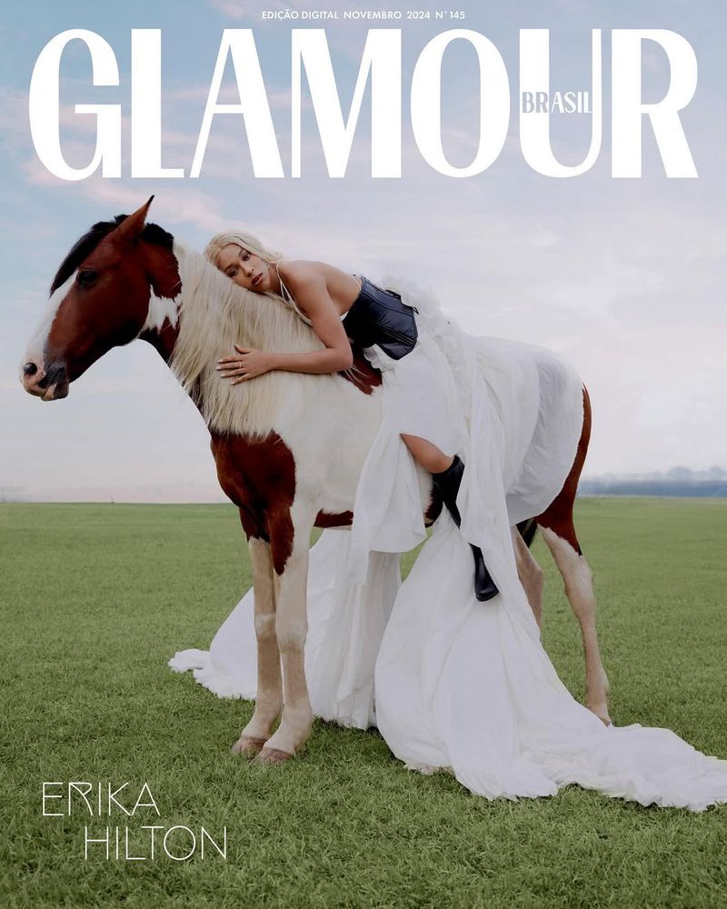 Glamour Brasil cover featuring Erika Hilton in a corset and white dress, leaning against a white and brown horse in a grassy field.