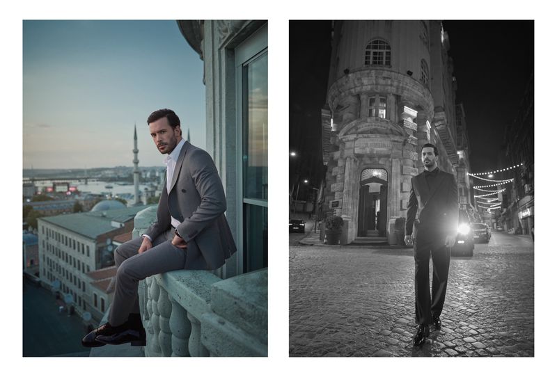 Man in a suit poses on a balcony overlooking Istanbul's skyline; grayscale shot of a man in a suit on a city street at night.