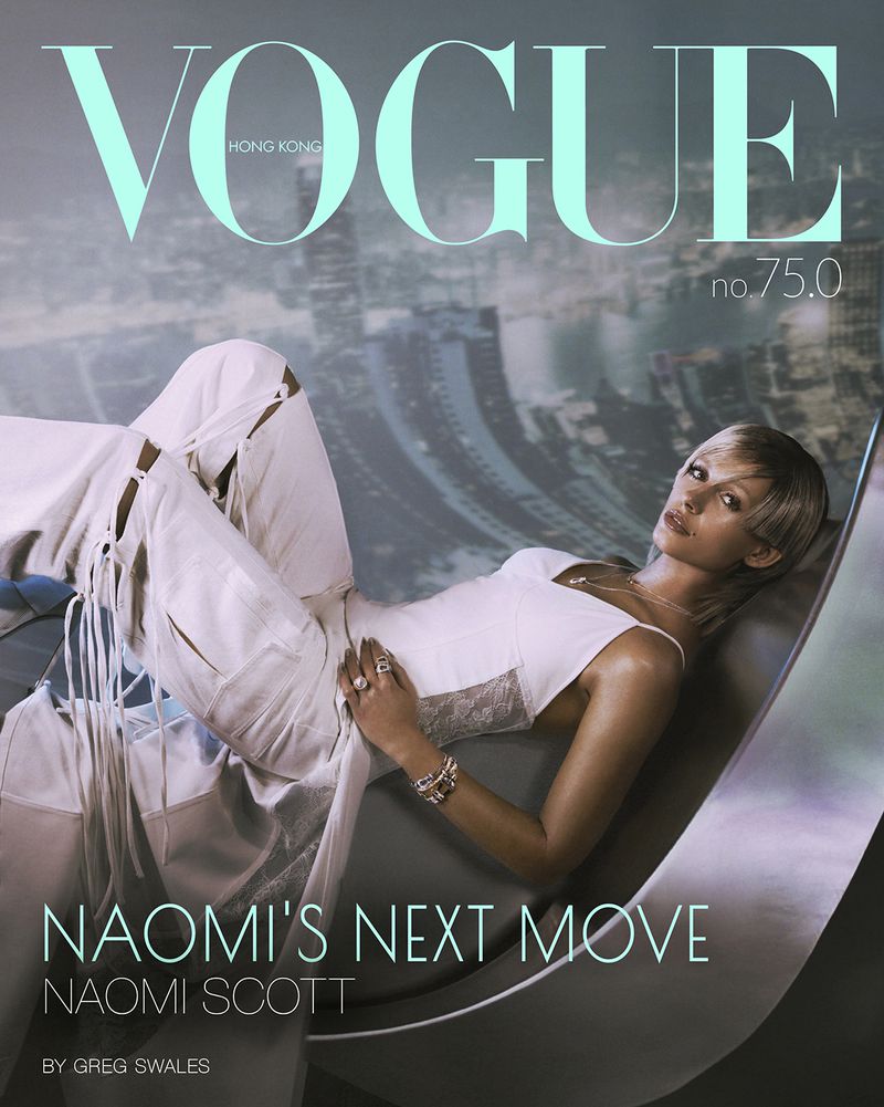 Vogue Hong Kong cover featuring Naomi Scott in a white outfit reclining against a cityscape backdrop with magazine masthead text.