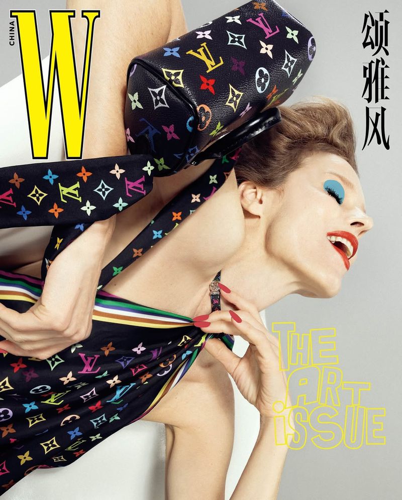 Editorial fashion magazine cover featuring a fair-skinned adult female model in a patterned black dress and carrying a Louis Vuitton handbag.