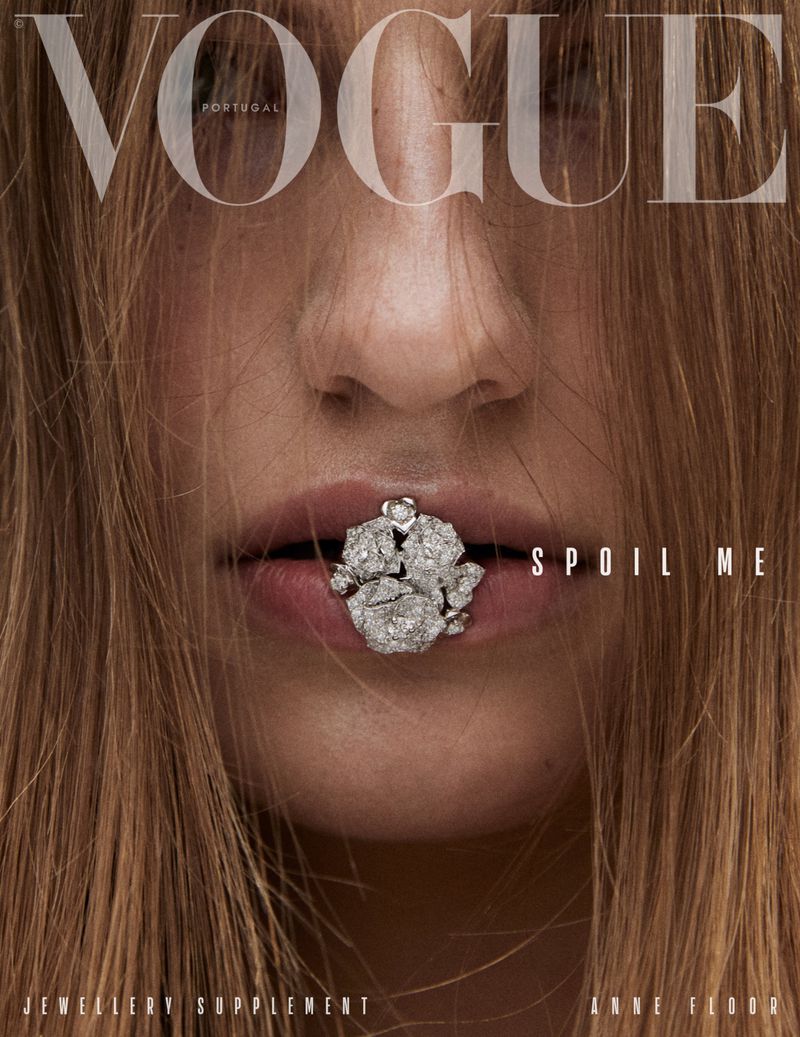 Vogue Portugal magazine cover featuring a model with jewelry in her mouth, fair skin, and brown hair partially obscuring the title.