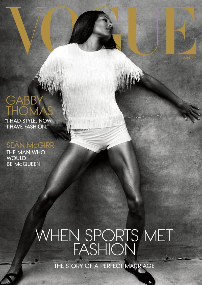 Vogue magazine cover featuring Gabby Thomas in a white fringe top and shorts, standing against a neutral background, bold gold text.